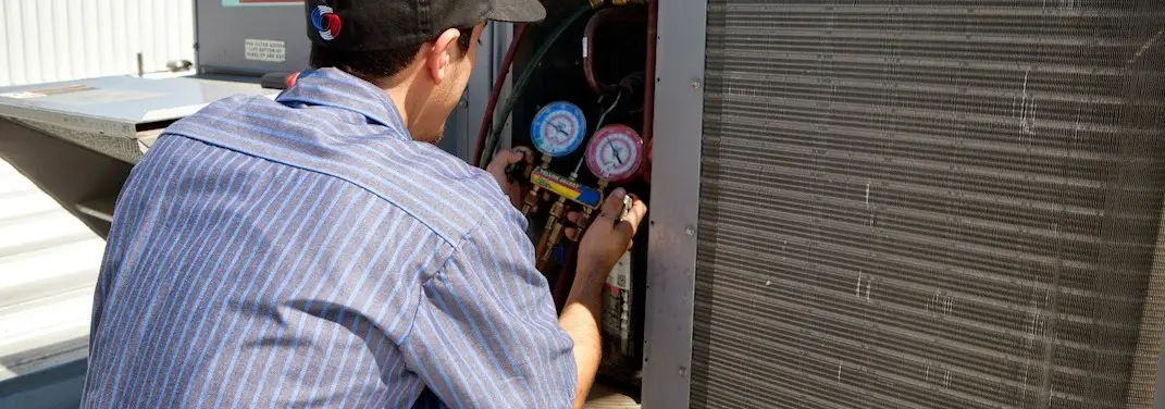 HVAC technician servicing a condenser unit in Waite Park