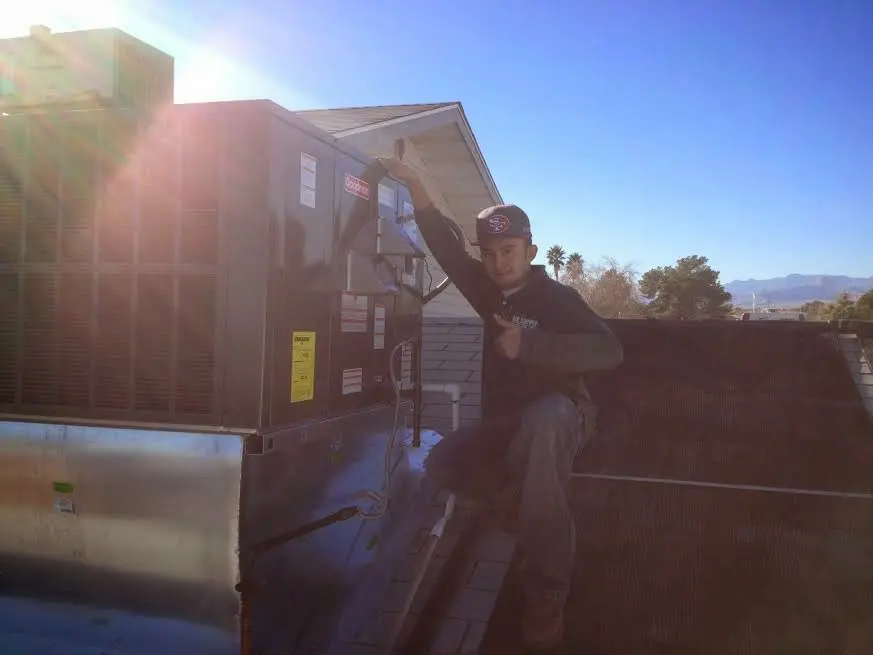 HVAC technician performing AC Tune-Up on a rooftop unit in Waite Park